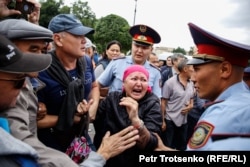 Женщина кричит на полицейских во время митинга в Алматы, 9 июня 2019 года.