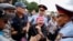 Женщина кричит на полицейских во время митинга в Алматы, 9 июня 2019 года.