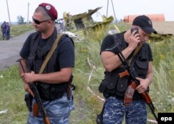 Pro-Russian armed rebels stand near debris at the main crash site of the Boeing 777 Malaysia Airlines Flight 17 on July 20, three days after it was shot down.