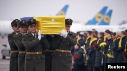 Soldiers carry a coffin containing the remains of one of the eleven Ukrainian victims of flight 752 during a memorial ceremony at the Boryspil International Airport, outside Kyiv, Ukraine January 19, 2020