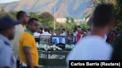 People watch the cortege carrying the ashes of Cuba's former President Fidel Castro drive toward Santa Ifigenia cemetery in Santiago on December 4.