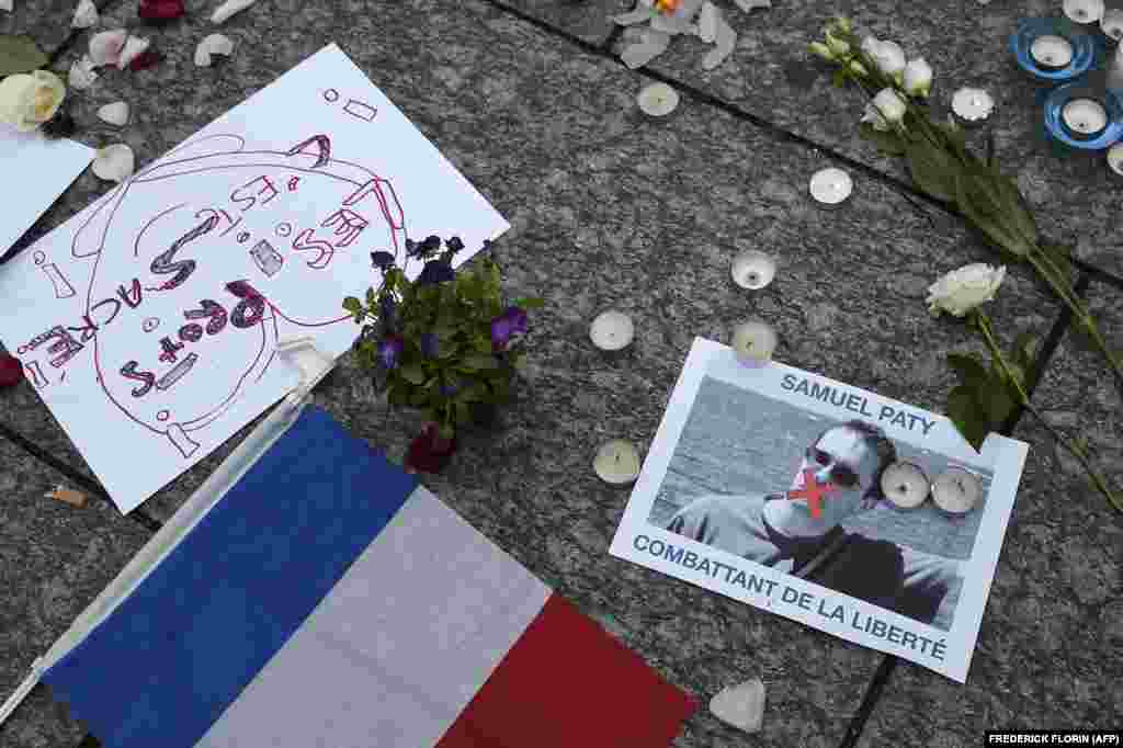 A photo shows a placard with the portrait of history teacher Samuel Paty and reading &quot;Freedom fighter&quot; as people gather in Strasbourg, eastern France, on October 18, 2020.