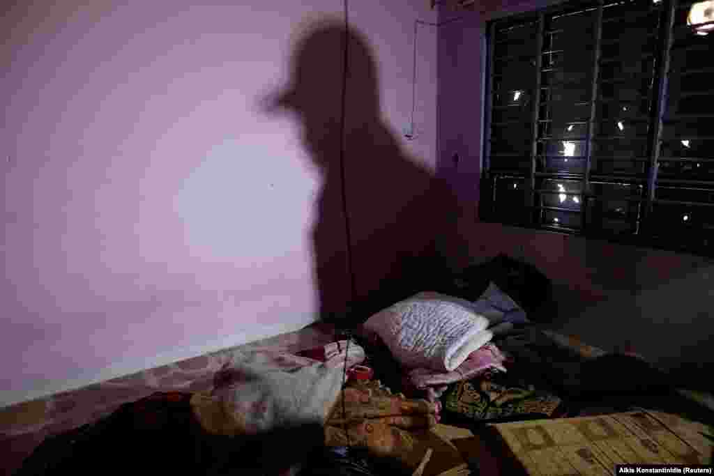 Discarded blankets piled inside a shuttered room used as a cell for men. 
