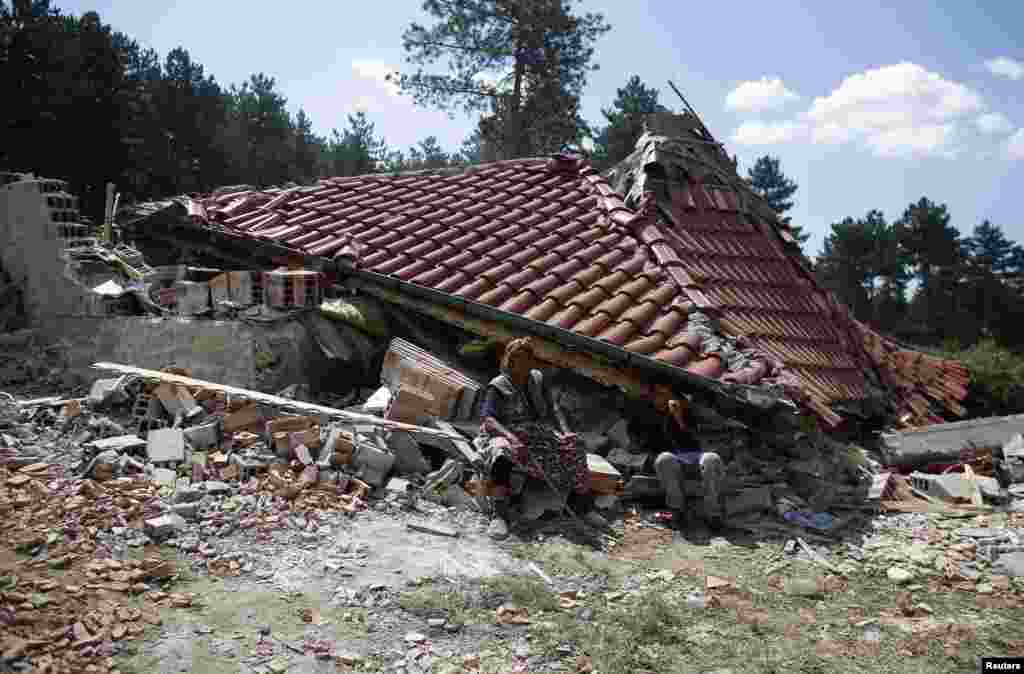 A Bulgarian woman sits in front of her house after it was demolished in a Romany suburb in the city of Stara Zagora.&nbsp;Municipal authorities started demolishing some 55 illegally built shacks and houses in the suburb on July 21. (Reuters/Stoyan Nenov)