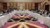 Qatari officials (center) take part in a meeting between U.S. special envoy Zalmay Khalilzad (second from left) and the U.S. delegation, and Sher Mohammad Abbas Stanikzai (sixth from the right) and the Taliban delegation, in Doha on February 26.