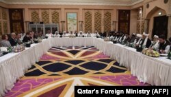 Qatari officials (center) take part in a meeting between U.S. special envoy Zalmay Khalilzad (second from left) and the U.S. delegation, and Sher Mohammad Abbas Stanikzai (sixth from the right) and the Taliban delegation, in Doha on February 26.