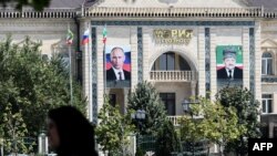 Здание мэрии Грозного, на фасаде которого размещены портреты президента России Владимира Путина и бывшего главы Чечни Ахмада Кадырова, отца Рамзана Кадырова. Июль 2017 года.