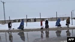 Afghans walking along a street in Kabul.