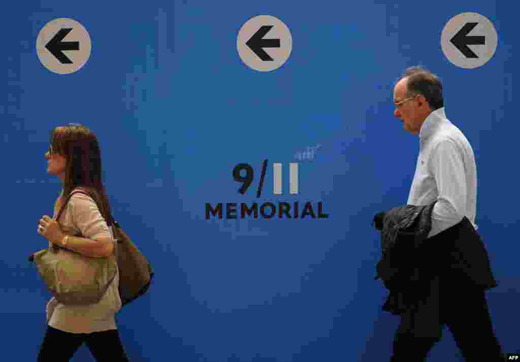 People walk along construction fences surrounding the 9/11 Memorial site in New York.