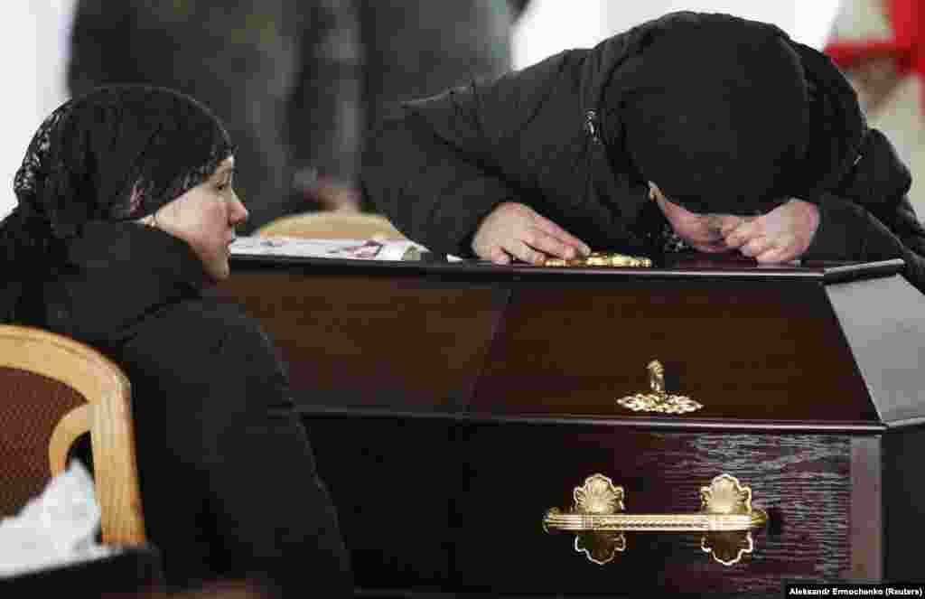 UKRAINE -- Relatives of one of the four servicemen of the self-proclaimed Luhansk People's Republic, who were killed last week in fighting against Ukrainian government forces, mourn next to his coffin during a funeral ceremony in the town of Kadiivka (Sta