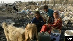 Children fill water containers at a garbage dump in Baghdad.