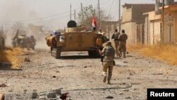 Iraqi Army units and Shi'ite militia gather in their battle against Islamic State militants outside Tal Afar on August 24.