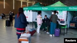 Putnici čekaju u redu da dobiju PCR test protiv korona virusa (COVID-19) pre putovanja na međunarodne letove. O.R. Međunarodni aerodrom Tambo u Johanesburgu, Južna Afrika, 26. novembar 2021. 