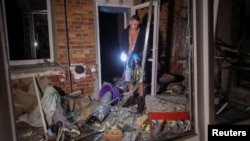 A resident looks at his heavily damaged house following a Russian air strike in Kharkiv on September 21.