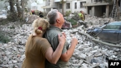 People standing outside a residential building partially destroyed as a result of Russian missile strikes in the western Ukrainian city of Lviv on July 30.
