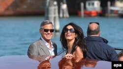 US actor George Clooney (L) and his fiance, Lebanese-British lawyer Amal Alamuddin (R) arrive in Venice, 26 September 2014