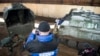 An OSCE monitor shoots video as Russia-backed separatists unload mortars from a truck near Donetsk.