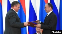 Armenia -- Defense Minister Seyran Ohanian (R) and his Russian counterpart Anatoly Serdyukov exchange copies of a newly signed Russian-Armenian military agreement, 20Aug2010.