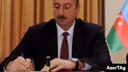 İlham Əliyev sənədlərə imza atarkən