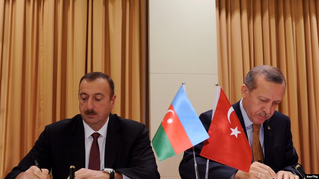 Azerbaijani President Ilham Aliyev (left) and Turkish Prime Minister Recep Tayyip Erdogan sign a protocol of the first meeting of Azerbaijan-Turkey High-Level Strategic Cooperation Council in Izmir on October 25.
