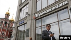 People walk past a branch of Promsvyazbank in Moscow.