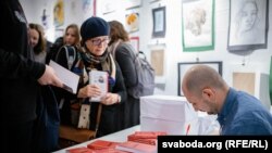 Аўтар Дзьмітры Гурневіч падпісвае кнігі наведнікам імпрэзы
