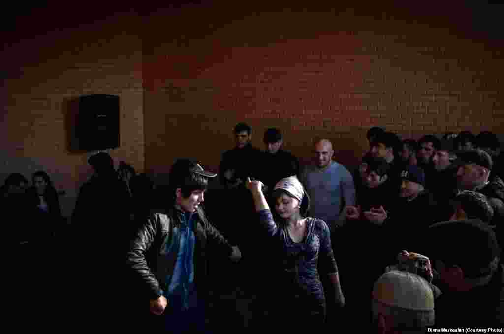 Party guests cheer as a couple dances Lezginka, a traditional dance in the North Caucasus.