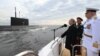 Ռուսաստանի նախագահ Վլադիմիր Պուտինը, պաշտպանության նախարար Սերգեյ Շոյգուն և Ռազմածովային նավատորմի հրամանատար, ծովակալ Նիկոլայ Եվմենովը Ռազմածովային ուժերի օրվան նվիրված շքերթի ժամանակ, հուլիս, 2021թ.