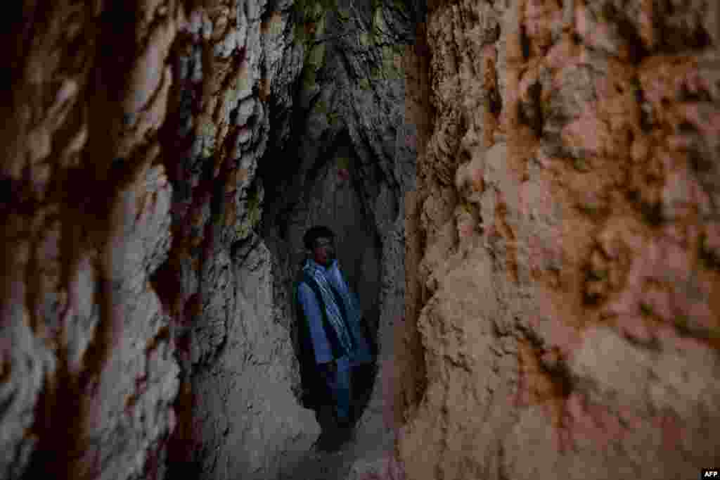 Miner Morad Ali stands in a crevasse dug out of the side of a mountain.
