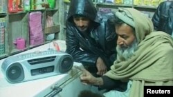 دوه افغان وګړي د راډیو د اورېدو پر مهال.