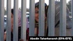 File - Female Iranian football fans watching from a distance as the Iranian national football team trains in Tehran.