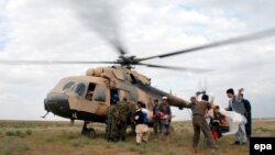 A helicopter distributes relief goods to flood-affected residents of Sheberghan, in northern Afghanistan, on April 25.