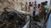 Afghan residents and family members of the victims on August 30 gather next to a damaged vehicle a day after a U.S. drone air strike in Kabul.