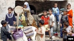 Displaced Iraqi children fill containers with dirty water in a neighborhood in eastern Baghdad. (file photo)