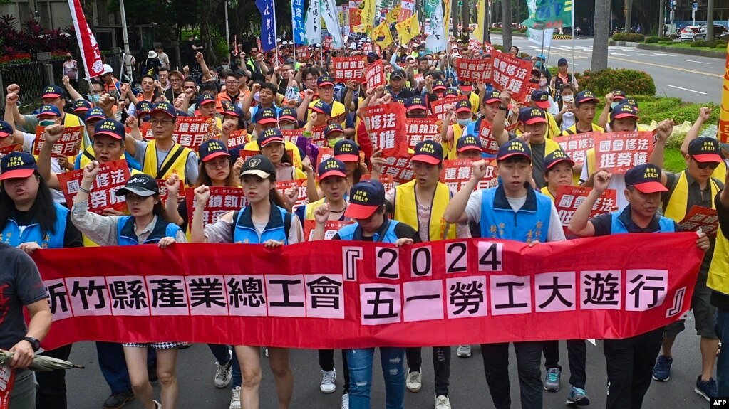 Tajvanski aktivisti marširaju ispred predsjedničke kancelarije tražeći od vlade da poveća plate i provede reforme zakona o radu u Tajpeju, 1. maja 2024.