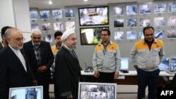 Iranian President Hassan Rouhani (3rd from L) and Iran's Atomic Energy Agency chief Ali Akbar Salehi (2nd from L) visit the control room of the Bushehr nuclear power plant in Bushehr, January 13, 2015