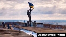 Ուկրաինայի ԶՈՒ զինծառայողները երկրի պետական դրոշն են բարձրացնում Խերսոնի մարզի՝ իրենց վերահսկողության տակ վերադարձված Վիսոկոպիլյա ավանում, 4-ը սեպտեմբերի, 2022թ.