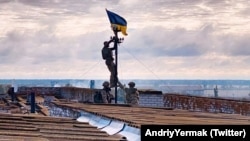 Украинские бойцы устанавливают флаг Украины в освобожденном поселке городского типа Высокополье в Херсонской области, 4 сентября 2022 года