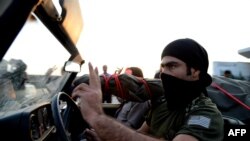 An Iraqi Kurd Peshmerga fighter flashes a victory sign as their convoy arrives at the Habur crossing along the Turkish-Iraqi border with heavy weapons on October 29.