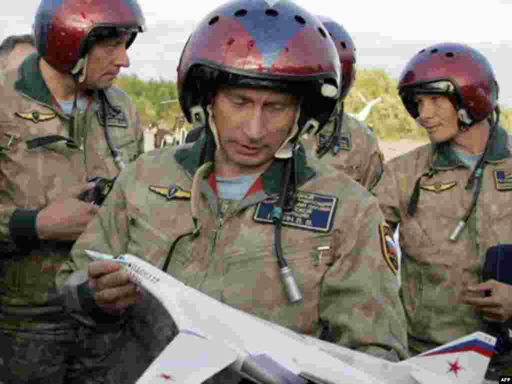 Russia – Russian President Vladimir Putin holds a replica of the Tupolev-160 strategic bomber jet at the at the Olenogorsk military airport, near Murmansk, 16Aug2005