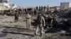 Afghan security personnel gather at the site of a suicide attack at a police compound in Maiwand district of Kandahar Province in late December.