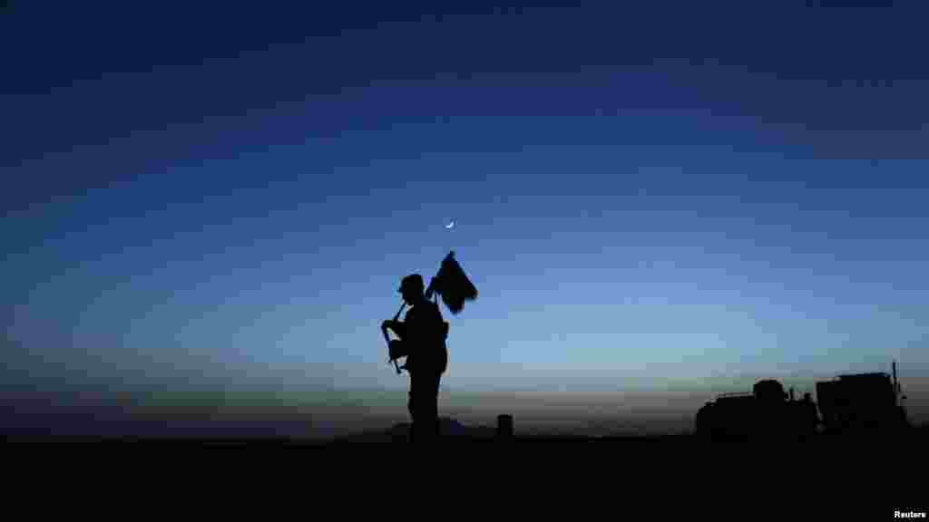 A U.S. Army piper plays the bagpipes at dusk in Zabul Province in Afghanistan on May 23. (Reuters/Tim Wimborne)