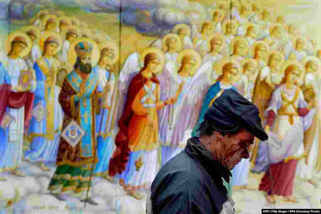 Czech Press Photo Photograph of the Year:&nbsp;A man wounded in clashes in Kyiv, Ukraine, walks past a religious painting.&nbsp;(epa/Filip Singer)&nbsp; 