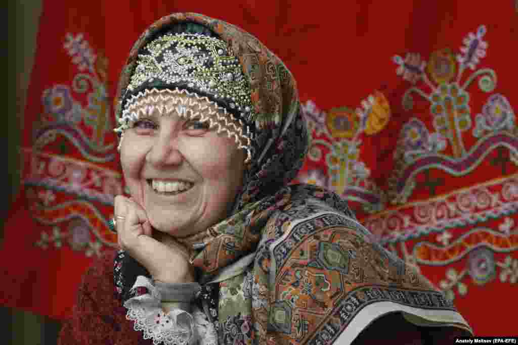 A souvenir seller smiles during the 2021 Agrorus international agricultural fair in St. Petersburg, Russia.