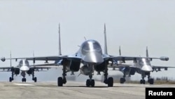 Российские боевые самолеты взлетают с авиабазы Хмеймим в Сирии. 15 марта 2016 года