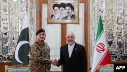 Iranian Parliament speaker Mohammad Baqer Qalibaf (right) shakes hands with Pakistan's army chief Asim Munir before their meeting in Tehran on April 16.