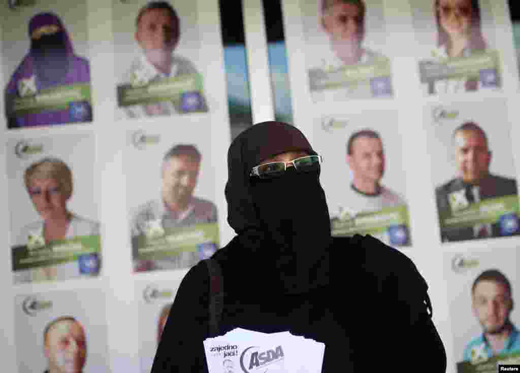 Indira Sinanovic, the first Bosnian woman to wear a niqab and run in local elections, shares promotional material in Zavidovici. (Reuters/Dado Ruvic)