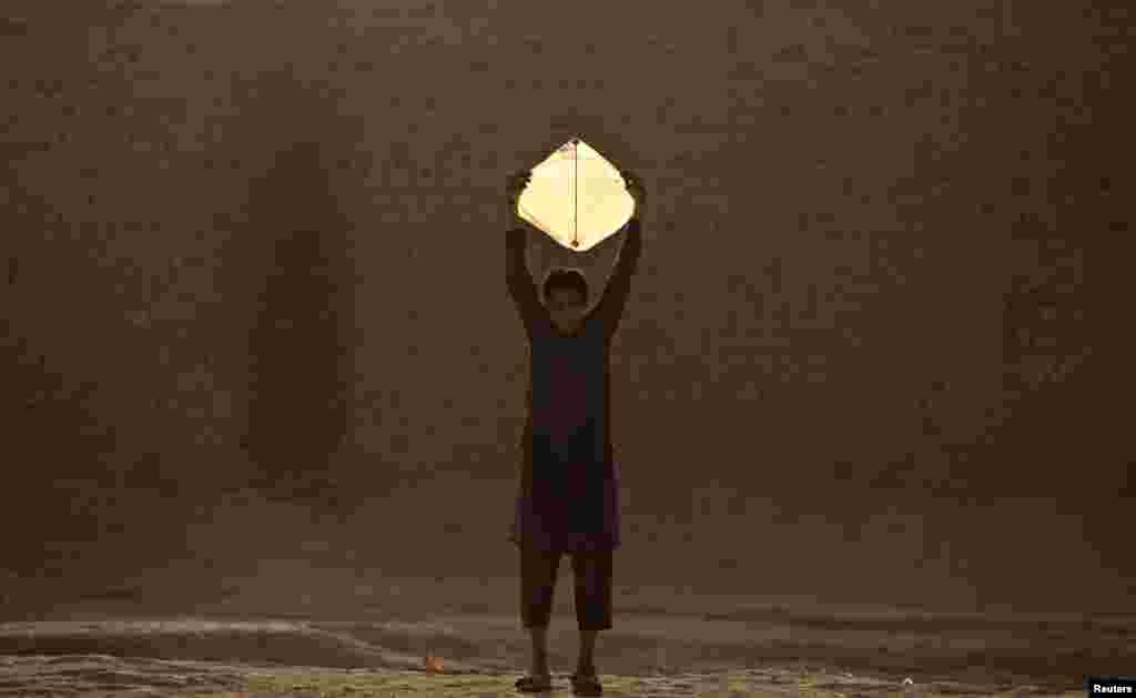 A boy prepares to release a kite as he plays with friends in Pehawar, Pakistan. (Reuters/Fayaz Aziz)