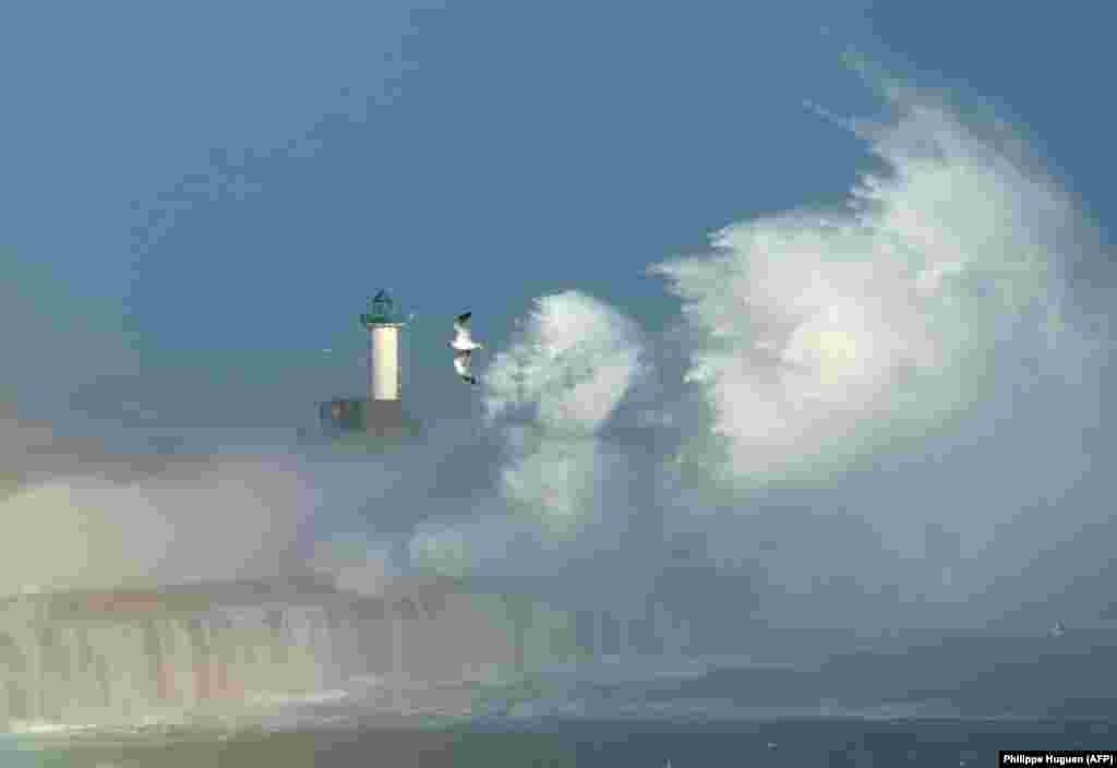 Waves break against a barrier in the port of Boulogne in northern France on October 28. A fierce storm cut off power to nearly 300,000 homes in Britain and France, and left at least two people dead.