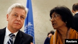 UN High Commissioner for Human Rights Navi Pillay (right) talks to Remigiusz Henczel, president of the Human Rights Council, before the 22nd session of the council at the United Nations in Geneva.